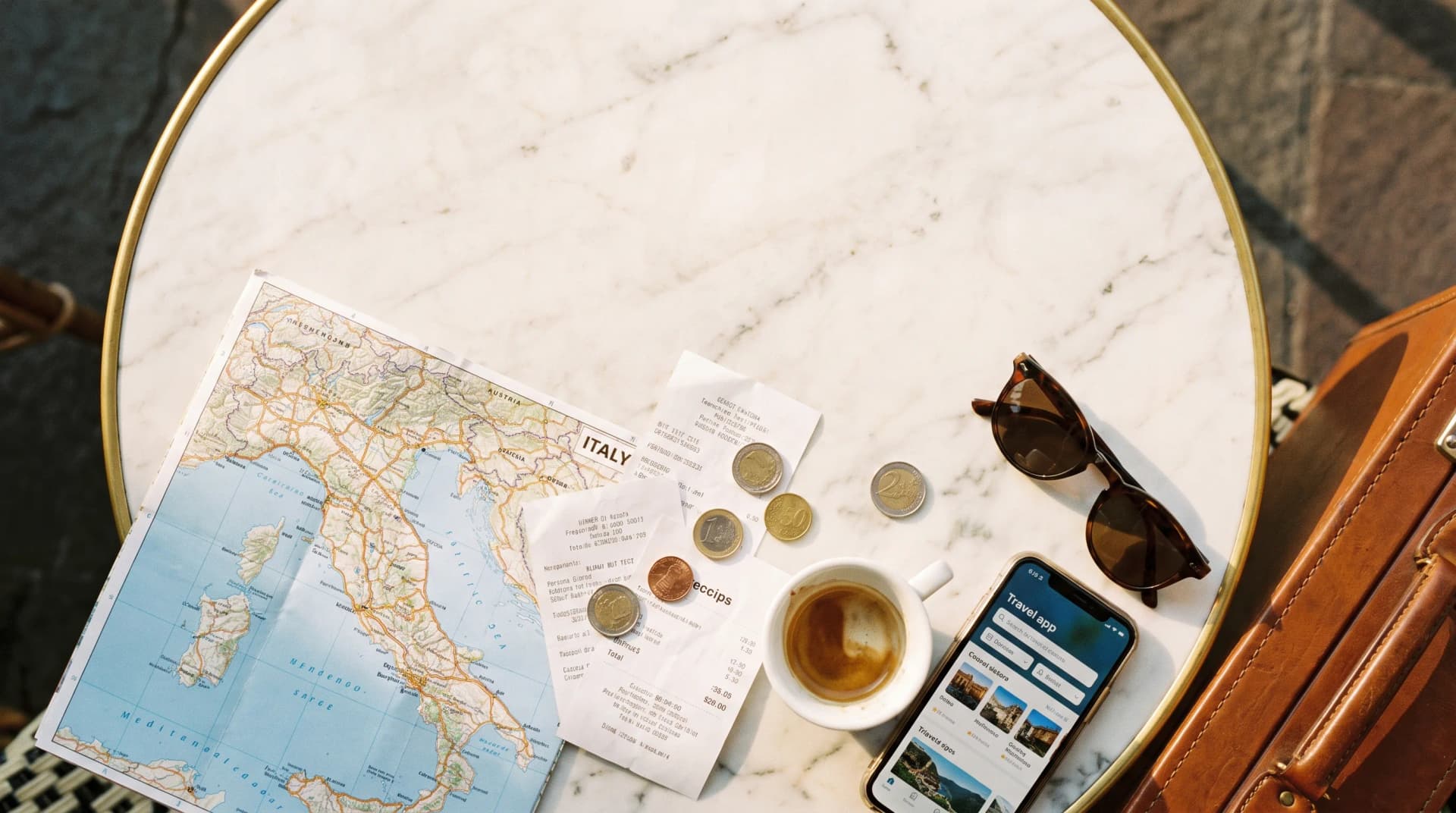 Travelers reviewing a map and receipts at an Italian cafe table.